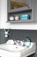 Detail of sink with grey panelling and painted cupboard