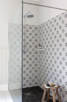 Detail of shower with tiles and chrome shower head.