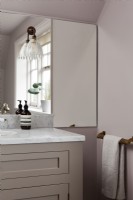 Detail of mirror, wall lights in classic pink bathroom