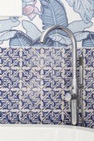 Detail of modern chrome bathroom taps for freestanding bath. Feature wallpaper

