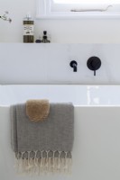Detail of freestanding contemporary bath with black taps. 
