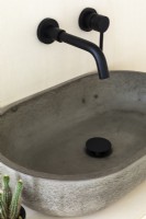 Close up of concrete sink and black taps