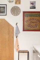 Kitchen wall with hooks, clock and artwork.