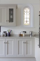 Grey shaker style kitchen with stained glass window
