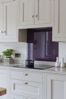 Induction hob in grey and purple kitchen.