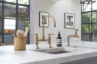 Detail of brass taps in shaker style kitchen