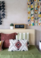 Detail of textured cushions and colourful wall hangings 