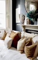 Detail of sofa with soft furnishings in luxurious fabrics and neutral tones 