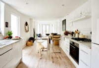 White, relaxed bright kitchen with natural wood floor. 