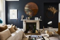 Dark painted walls in a living room with marble fireplace