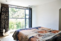 Patterned bed throw over the bed with view to garden 