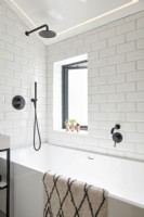 White tiled bathroom with black accessories 