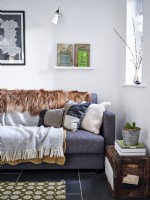 Retro cushions and blankets on grey sofa