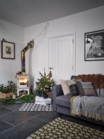 Nordic living room featuring sofa, Christmas tree and a wood burning stove
