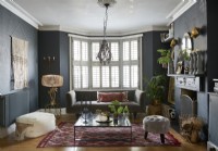 Eclectic living room in a victorian house with a vintage , modern and boho mix of furniture. 