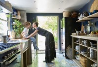 Owner and her son in the kitchen with view to the garden. 