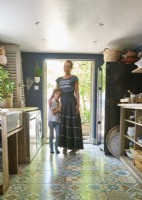 Owner and her son in the kitchen infant of doors leading to the garden. 