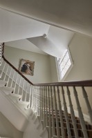 Stairway with white walls and framed painting.  