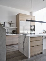 Modern kitchen featuring a marble and wooden island unit