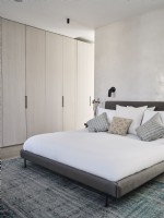 Modern bedroom in muted tones featuring built in wardrobe