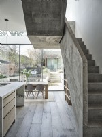Dining room featuring concrete staircase and glass bi fold doors