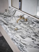 Grey and white marble sink with gold taps