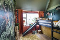 Jungle themed childrens room with slide from bunk bed