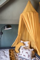 Yellow canopy over childrens bed