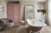 Feminine bathroom with pink rolltop bath
