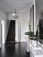 Black and white hallway featuring a chandelier 