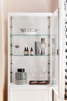 Detail of dining room display cabinet with bowls, vases and glassware