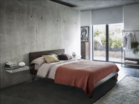 Orange bed against concrete wall