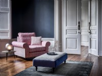 Pink chair in blue room with rug