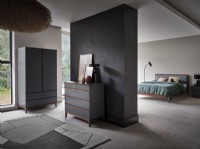 Grey chest of drawers against grey feature wall in bedroom