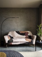 Patterned sofa in front of textured concrete wall