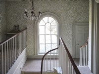 Traditional hallway featuring a round top window