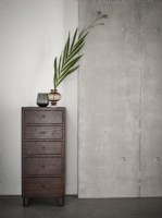 Chest of drawers next to industrial concrete wall