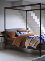 Four poster bed with stairs in background