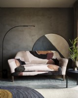 Patterned sofa in front of textured concrete wall