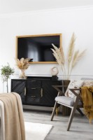 Wall mounted television above a sideboard in a modern living room