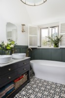 Corner in a country bathroom with twin wash basin unit and free standing bath