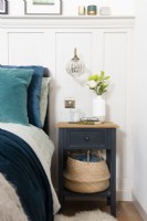 Bedside table with basket in a country style bedroom