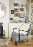 Living room with retro armchair, drinks corner and vintage oil paintings on the wall.