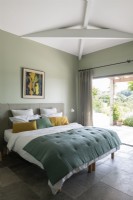 Modern bedroom with patio doors leading to terrace in summer