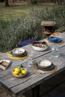 Rustic wooden outdoor dining table laid for lunch