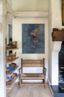 Artwork above wooden armchair in country living room