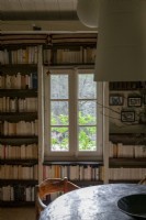 View of rustic window between built-in bookshelves