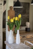 Detail of yellow tulips - cut flowers in white ceramic vases