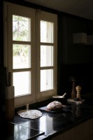 Detail of black kitchen worktop in country kitchen next to window