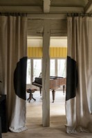 View through curtains to grand piano in country house